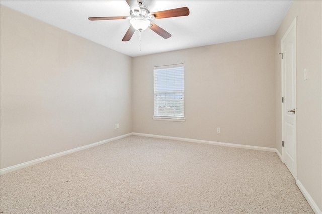 carpeted empty room with a ceiling fan and baseboards