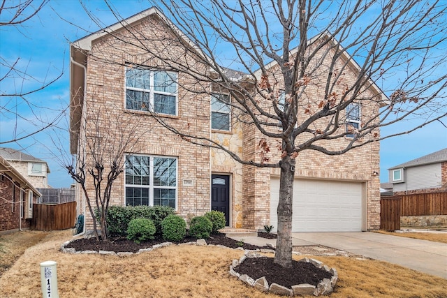 traditional-style house with an attached garage, fence, concrete driveway, and brick siding