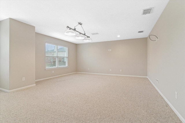 spare room with light colored carpet, visible vents, and baseboards