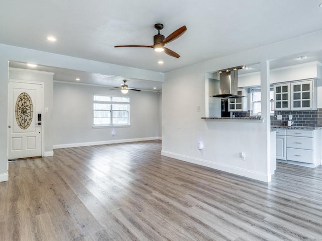 unfurnished living room featuring light wood-type flooring, ceiling fan, baseboards, and recessed lighting