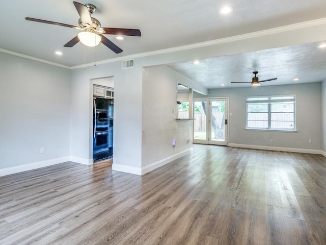 unfurnished living room featuring visible vents, baseboards, and wood finished floors