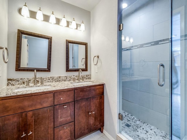 full bathroom featuring double vanity, a sink, and a shower stall