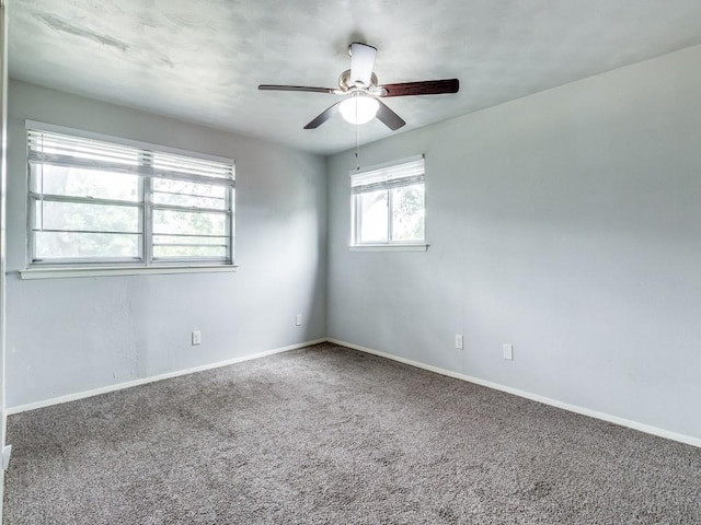 unfurnished room with carpet floors, baseboards, and a ceiling fan