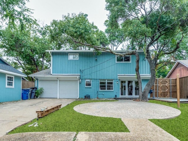 view of front of home with driveway, french doors, fence, and brick siding