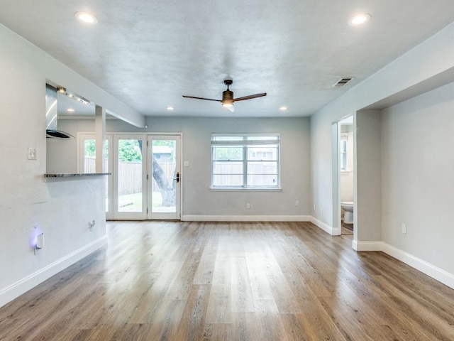 unfurnished living room with baseboards, visible vents, wood finished floors, and recessed lighting