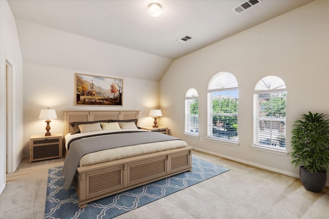 bedroom featuring lofted ceiling, visible vents, and light carpet