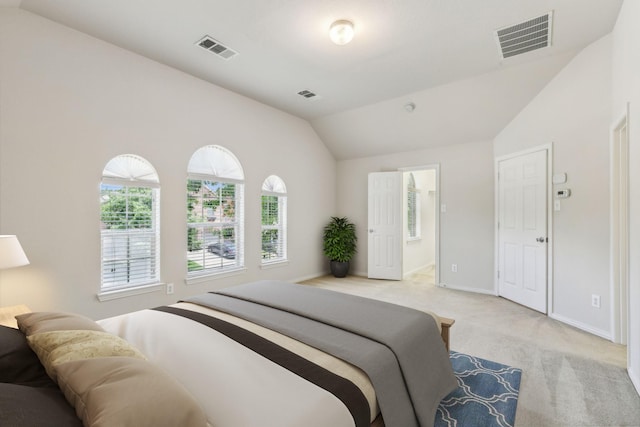 bedroom with visible vents, vaulted ceiling, and light colored carpet