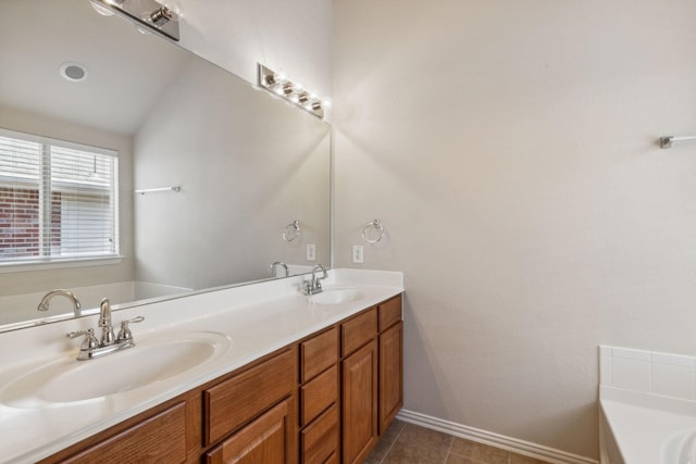 full bath featuring a garden tub, double vanity, a sink, and baseboards