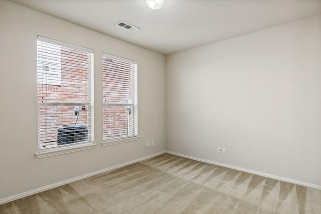 unfurnished room featuring baseboards, visible vents, and light colored carpet