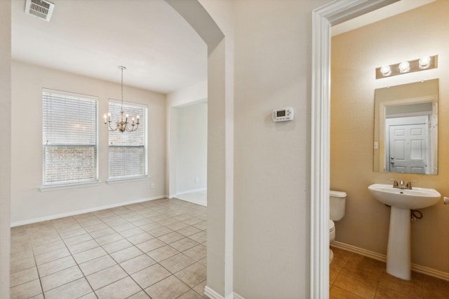 bathroom featuring visible vents, baseboards, toilet, tile patterned flooring, and a notable chandelier