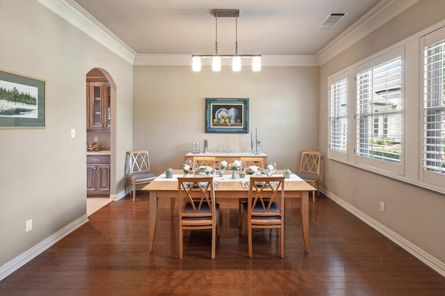 unfurnished dining area with arched walkways, dark wood-type flooring, visible vents, and crown molding