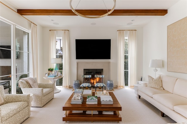 carpeted living room featuring a glass covered fireplace and beam ceiling