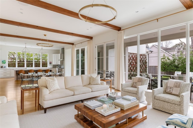 living room with light wood-style flooring and beam ceiling