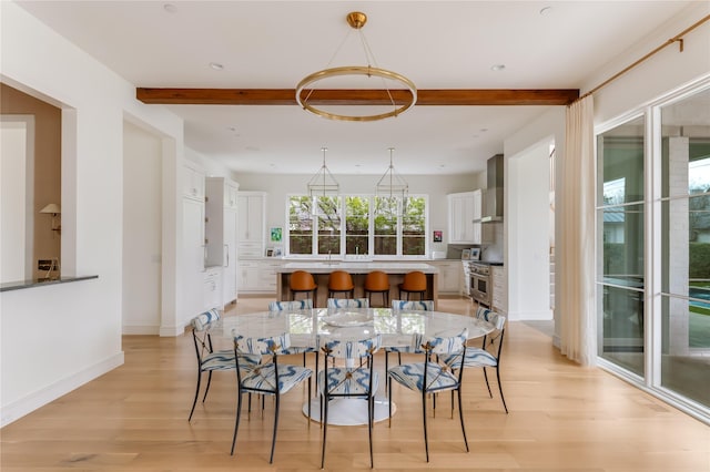 dining area with baseboards, beamed ceiling, and light wood-style floors