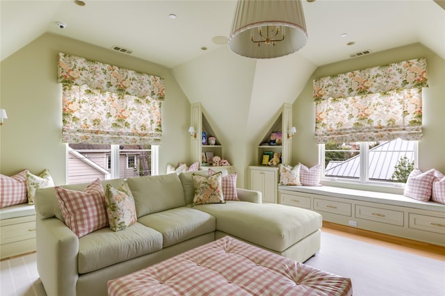 living room with light wood finished floors, visible vents, and vaulted ceiling