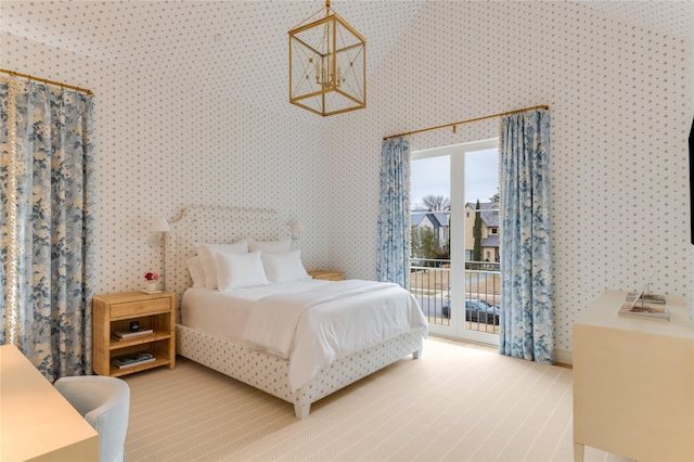 carpeted bedroom with access to outside, an inviting chandelier, and wallpapered walls