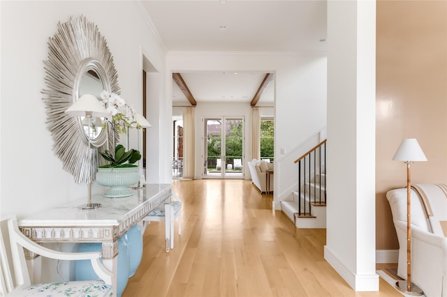 foyer with baseboards, stairs, light wood-style floors, ornamental molding, and beamed ceiling