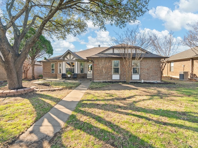 view of front facade featuring brick siding, central AC, and a front yard