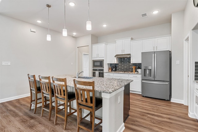 kitchen with visible vents, appliances with stainless steel finishes, tasteful backsplash, and wood finished floors