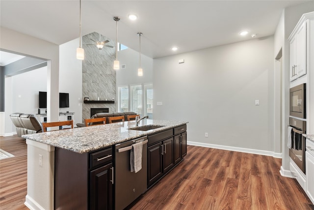 kitchen featuring appliances with stainless steel finishes, open floor plan, dark wood-type flooring, and a sink