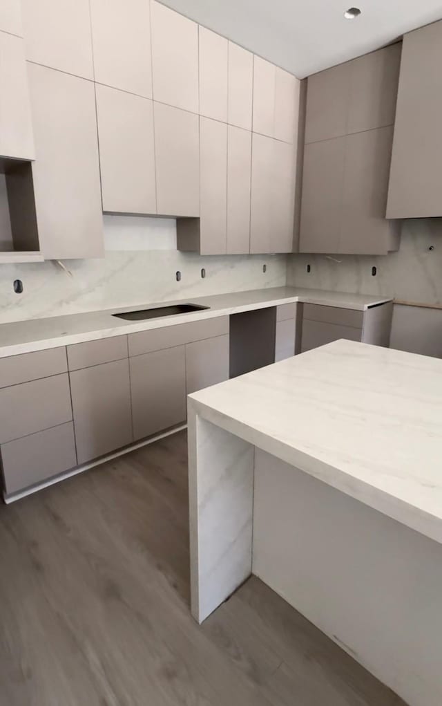 kitchen with backsplash, modern cabinets, wood finished floors, and black cooktop