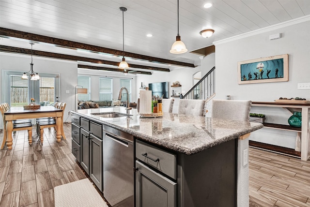 kitchen featuring wood finished floors, a sink, open floor plan, stainless steel dishwasher, and beamed ceiling