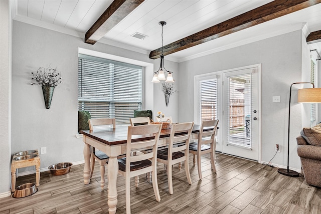 dining area with visible vents, plenty of natural light, light wood-style flooring, and beamed ceiling