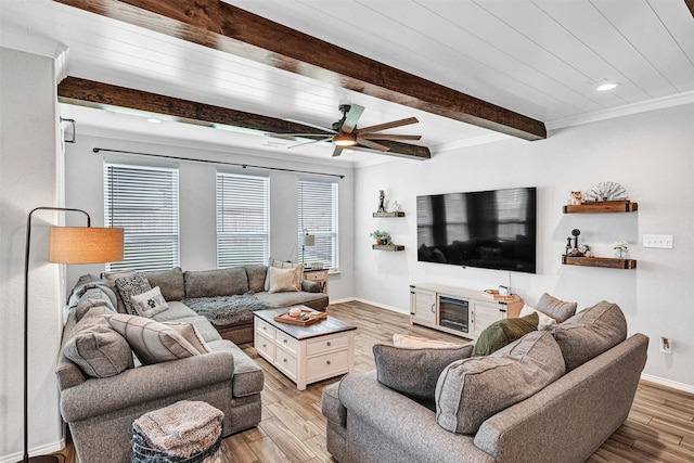 living room with crown molding, beamed ceiling, light wood-style flooring, and baseboards