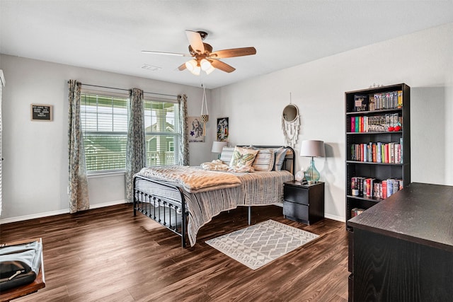 bedroom with baseboards, visible vents, dark wood finished floors, and a ceiling fan