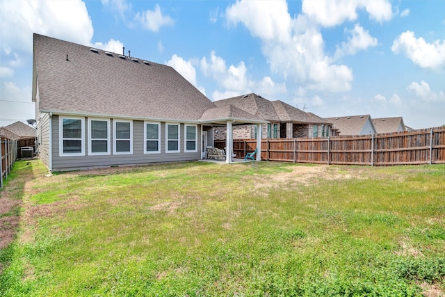 rear view of house featuring a fenced backyard, a shingled roof, cooling unit, and a lawn