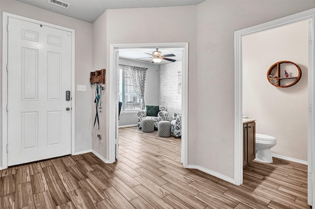 entrance foyer with wood finished floors, visible vents, and baseboards