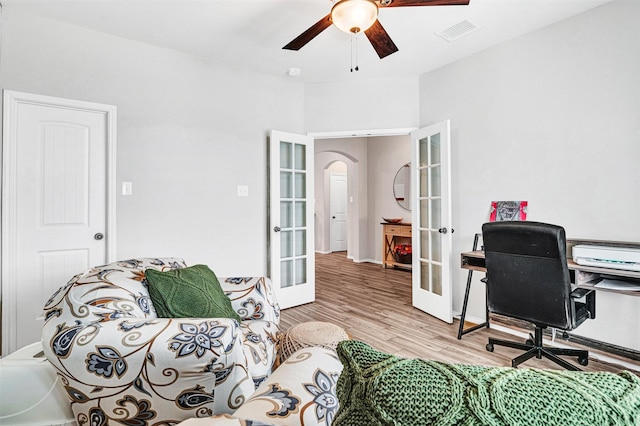 office area featuring arched walkways, wood finished floors, visible vents, a ceiling fan, and french doors