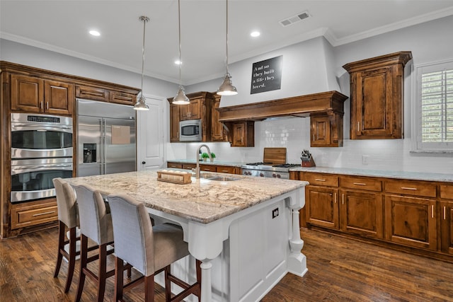 kitchen featuring built in appliances, a sink, visible vents, decorative backsplash, and crown molding