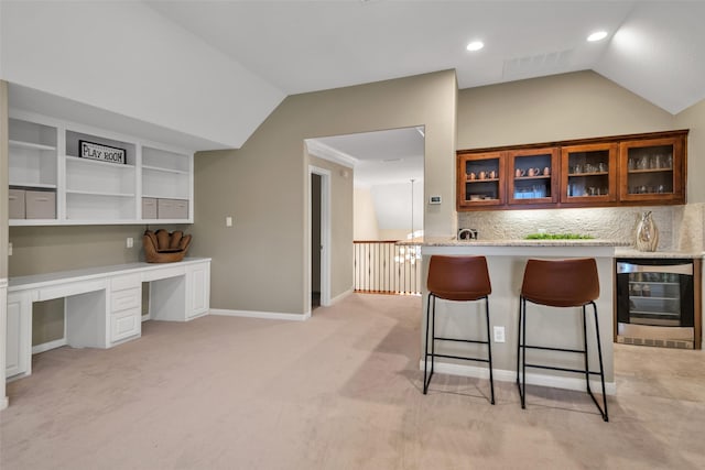 2204 Emerson Ln, Carrollton, TX 75010 - kitchen with wine cooler, lofted ceiling, a kitchen bar, glass insert cabinets, and tasteful backsplash