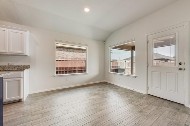 unfurnished dining area with light wood-style flooring, baseboards, vaulted ceiling, and recessed lighting