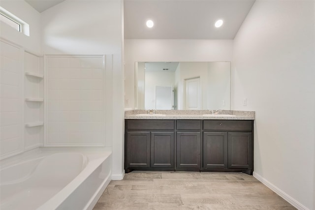 bathroom with double vanity, shower / bath combination, a sink, and baseboards