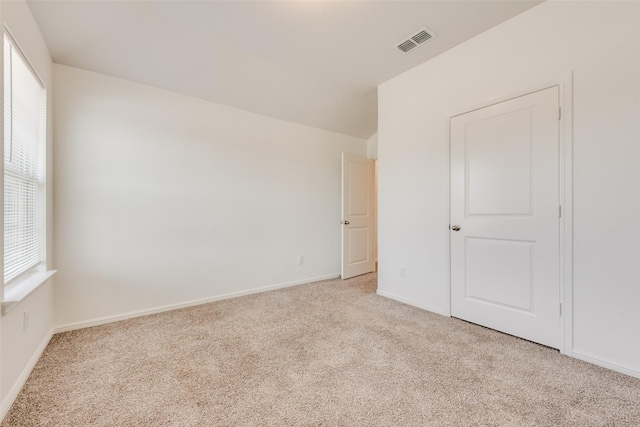 unfurnished bedroom featuring carpet flooring, visible vents, and baseboards