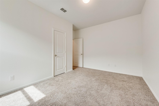 unfurnished room with light carpet, baseboards, and visible vents