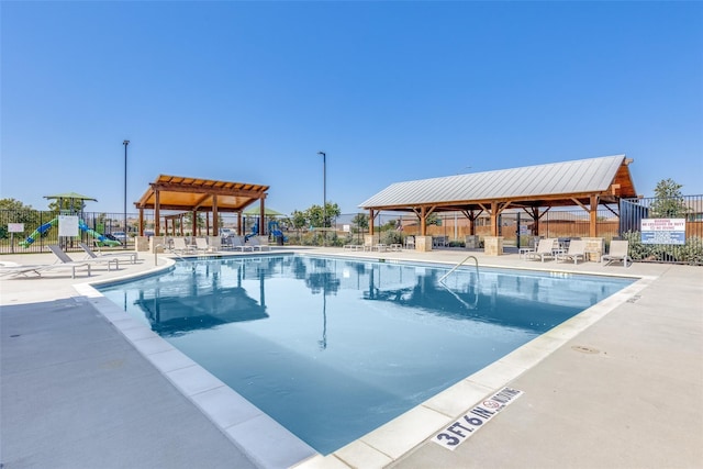 community pool featuring playground community, a patio area, fence, and a pergola