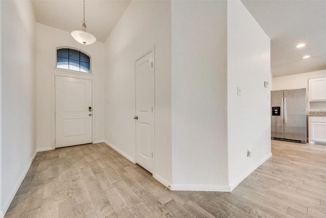 entrance foyer featuring light wood-style flooring, baseboards, and recessed lighting