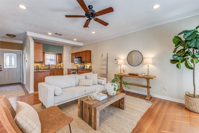 living room featuring crown molding, recessed lighting, visible vents, light wood-style floors, and baseboards