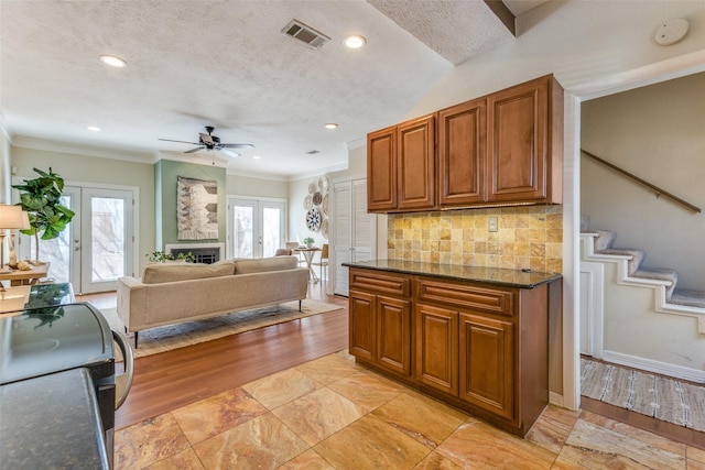 kitchen featuring french doors, a healthy amount of sunlight, visible vents, and brown cabinets