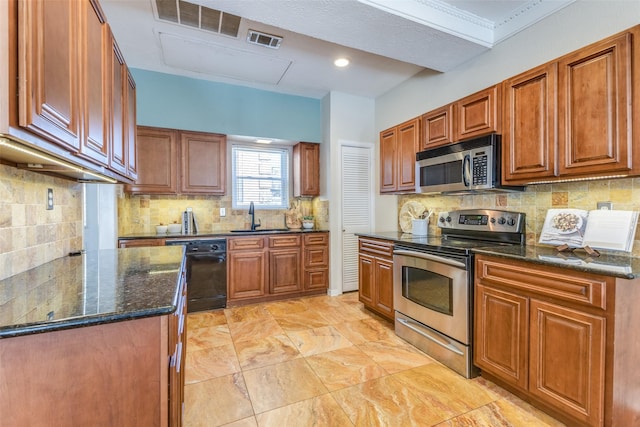 kitchen featuring stainless steel appliances, a sink, visible vents, brown cabinetry, and dark stone countertops