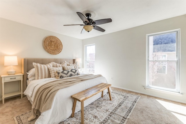 bedroom featuring ceiling fan, baseboards, and light colored carpet