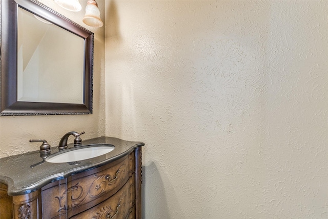 bathroom with a textured wall and vanity