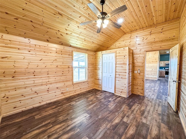 unfurnished bedroom with dark wood finished floors, vaulted ceiling, wooden walls, and wooden ceiling