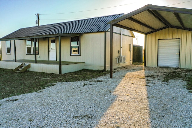 view of side of property featuring metal roof, a carport, and a porch