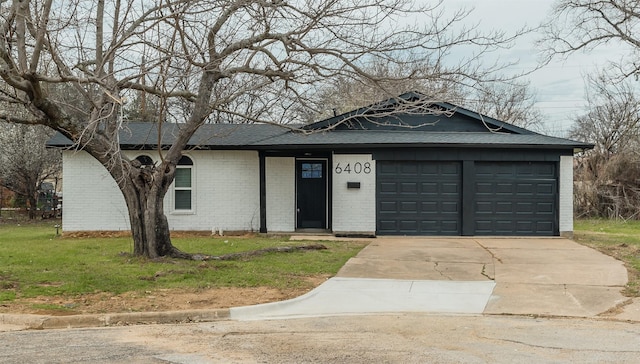 ranch-style house featuring an attached garage, brick siding, a shingled roof, concrete driveway, and a front lawn