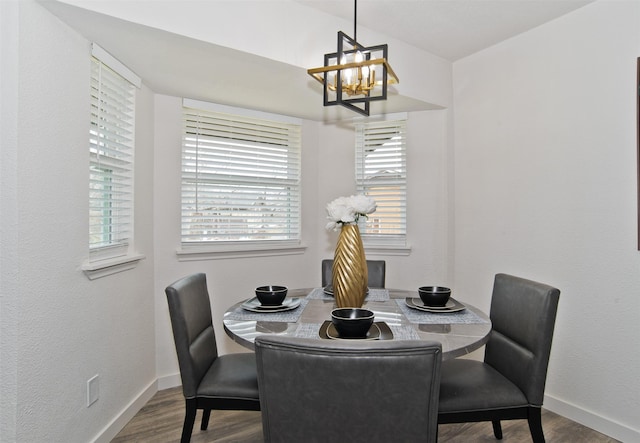 dining room featuring an inviting chandelier, wood finished floors, and baseboards