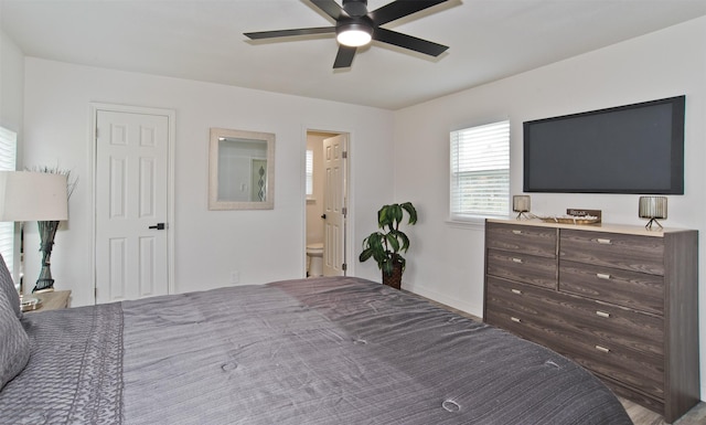 bedroom featuring connected bathroom, ceiling fan, and baseboards